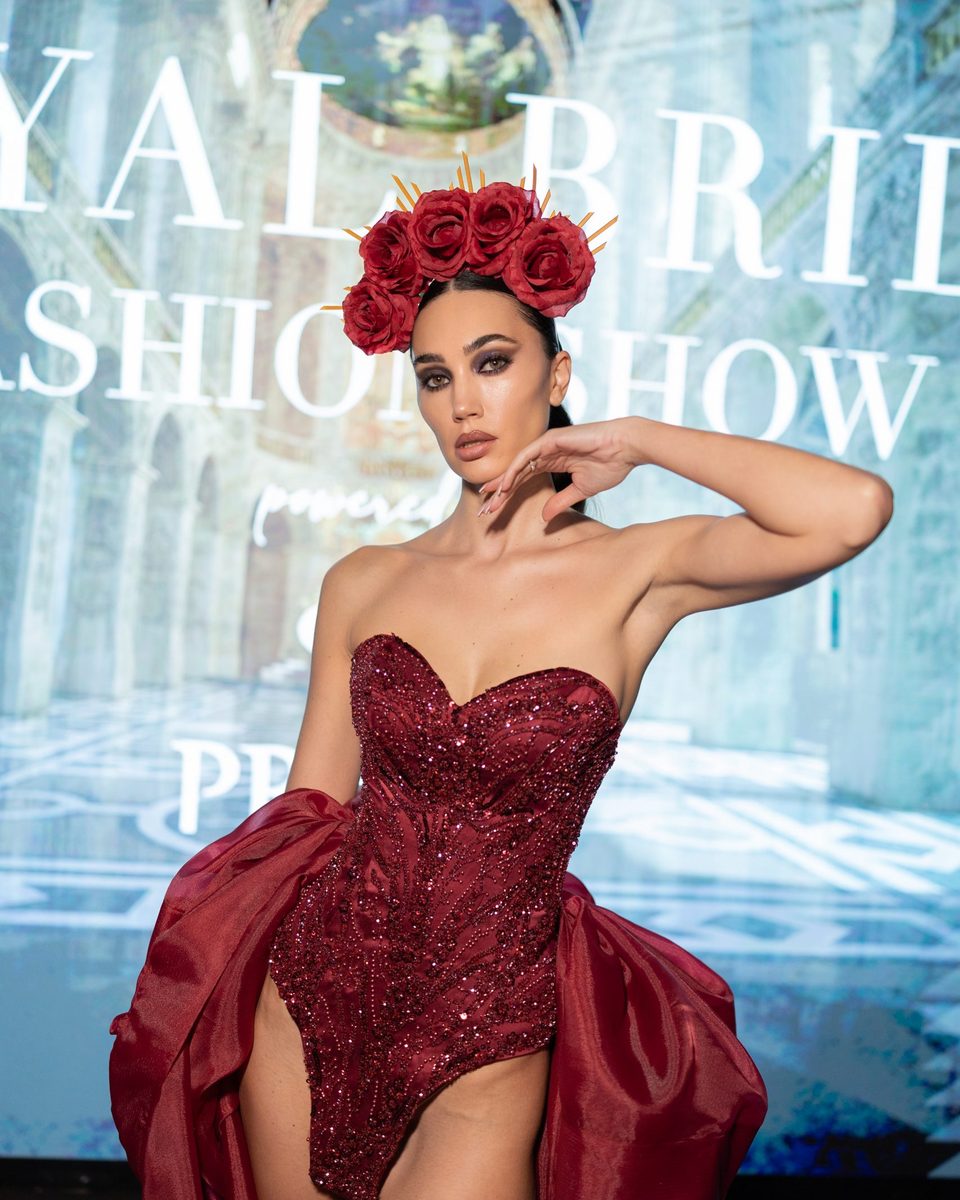 Dubravka Švegar in a burgundy sequinned costume and a crown of red roses, at a fashion show